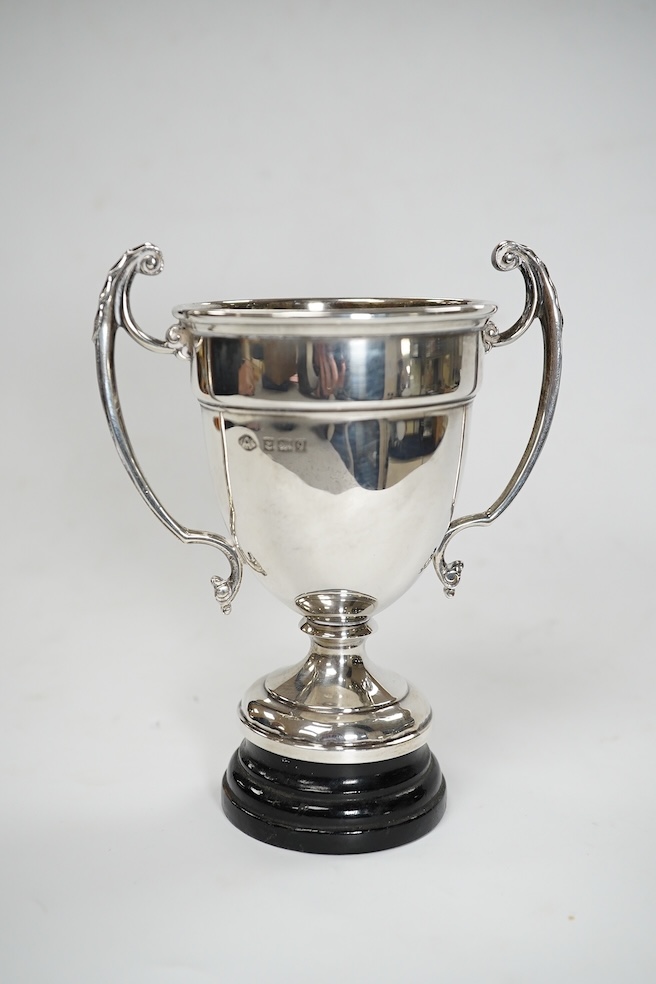 A pair of Edwardian silver dwarf candlesticks, of tapering design, C.S Green & Co, Birmingham, 1908, 13.2cm, together with four small silver trophy cups, a silver napkin ring and a plated trophy cup. Condition - poor to